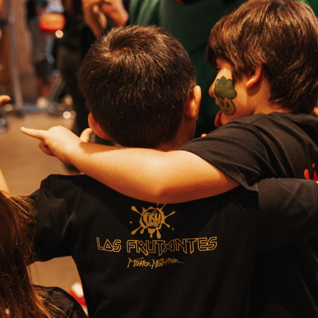 Dos niños esperando a sus artistias favoritos con sus poleras de clásicos del rock.